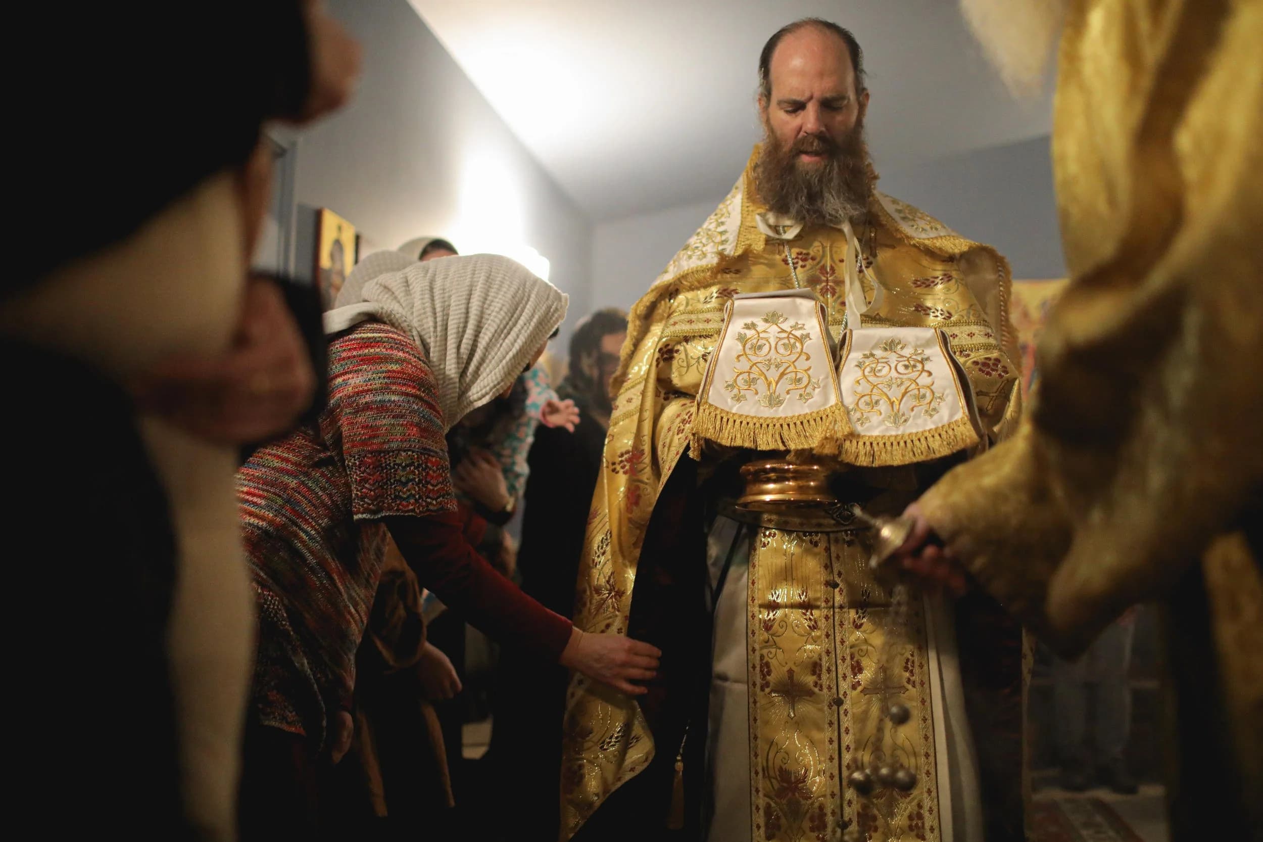 Orthodox priest and parishioner during a church service.