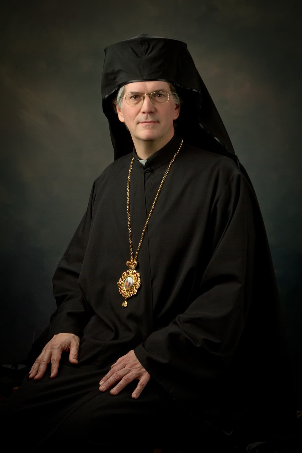 Portrait of His Grace Bishop Anthony seated in black clerical attire.